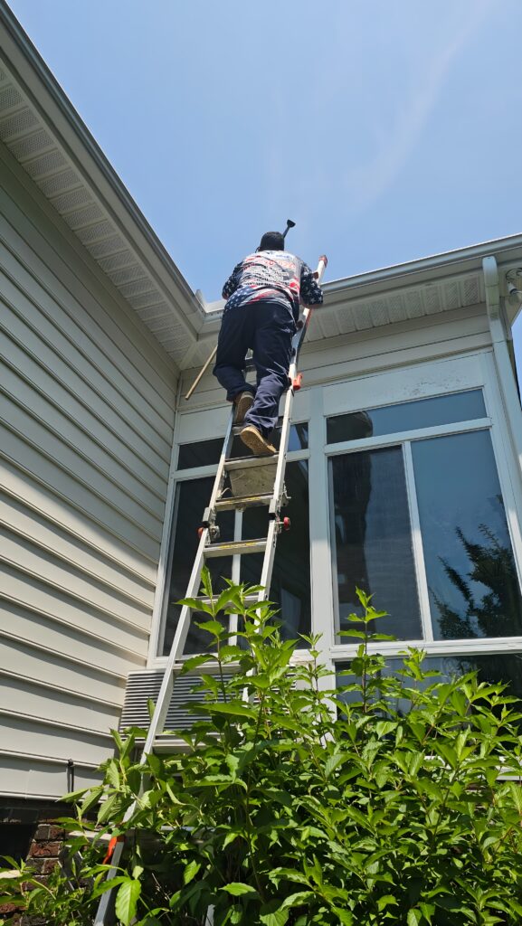 Man on a ladder. Gutter cleaning in Clayton